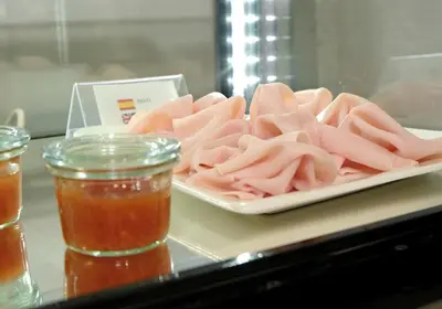 a plate of pink meat on a table with sauces at Hotel Belcaire in Vall de Uixó