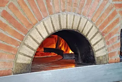 a brick oven with a pizza in it at Hotel Belcaire in Vall de Uixó