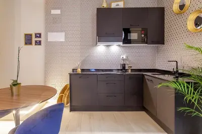 a kitchen with black cabinets and a wooden table at Mediterranean Flats Plaza Redonda in Valencia