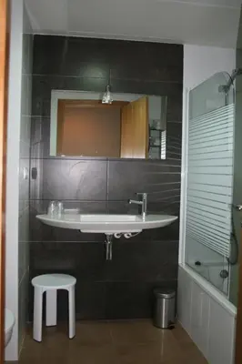 a bathroom with a sink and a stool at Hotel Ciutat de Carlet in Carlet
