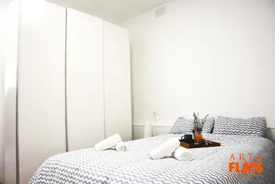 a bedroom with a bed with blue and white sheets at Calle Cuenca in Valencia