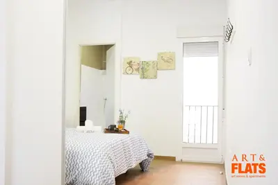 a bedroom with a bed and a white wall at Calle Cuenca in Valencia