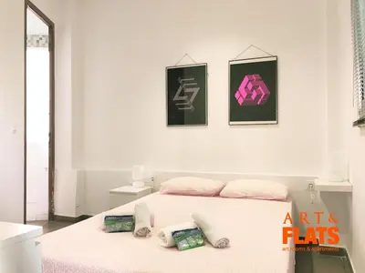 a bedroom with a bed with three pictures on the wall at CALLE CUENCA 2 in Valencia