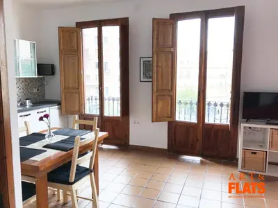 a dining room with a table and a kitchen with windows at CALLE CUENCA 2 in Valencia