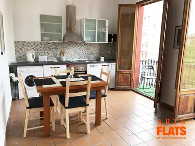 a kitchen with a wooden table with chairs and a stove at CALLE CUENCA 2 in Valencia