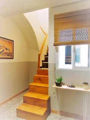 a staircase in a living room with a window at Casa Maritim Cabanyal in Valencia