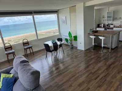 a living room with a couch and a table with chairs at Gran Apartamento, un lujo en playa El Saler - Valencia in El Saler