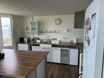 a kitchen with white cabinets and a clock on the wall at Gran Apartamento, un lujo en playa El Saler - Valencia in El Saler