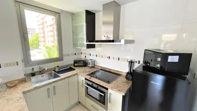 a kitchen with a black refrigerator and a sink at BEACH VALENCIA LUXURY A40-35 Apartment with terrace and sea views in Valencia