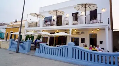 a restaurant with tables and umbrellas in front of a building at BEACH VALENCIA LUXURY A40-35 Apartment with terrace and sea views in Valencia