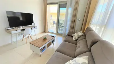 a living room with a couch and a flat screen tv at BEACH VALENCIA LUXURY A40-35 Apartment with terrace and sea views in Valencia