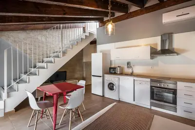 a kitchen with a red table and white chairs at Catalina Suites San Nicolas in Valencia