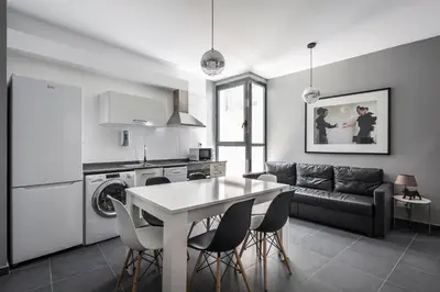 a kitchen and living room with a table and chairs at Catalina Suites San Nicolas in Valencia