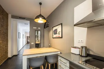 a kitchen with a counter and two stools at Catalina Suites San Nicolas in Valencia