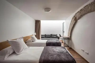a hotel room with two beds and a couch at Catalina Suites San Nicolas in Valencia