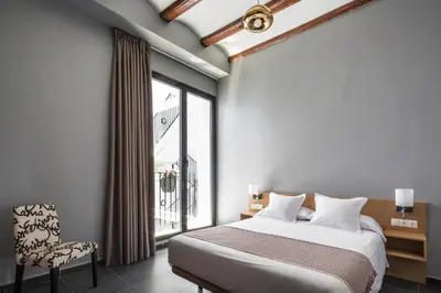 a bedroom with a bed and a large window at Catalina Suites San Nicolas in Valencia