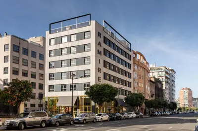 a tall building on a city street with parked cars at Ramirez Flats Valencia in Valencia
