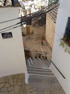 a stairway with a person walking down the stairs at La Muralla Del Castillo in Chulilla