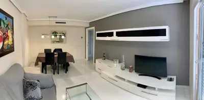 a living room with a couch and a table with a television at Apartamento Nuevo con Gran Terraza y Wifi en Canet in Canet de Berenguer