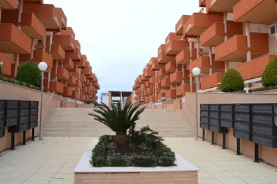 a courtyard of an apartment building with stairs and a plant at Apartamento Nuevo con Gran Terraza y Wifi en Canet in Canet de Berenguer