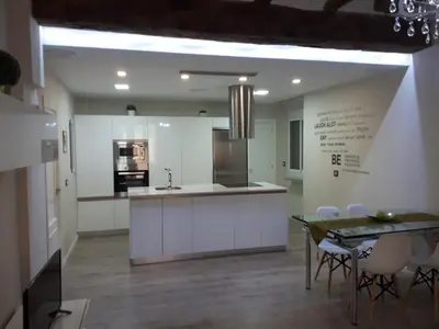 a kitchen with white cabinets and a table and chairs at Amplio apartamento en centro histórico in Valencia