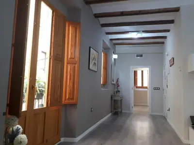 an empty hallway with a wooden door and windows at Amplio apartamento en centro histórico in Valencia