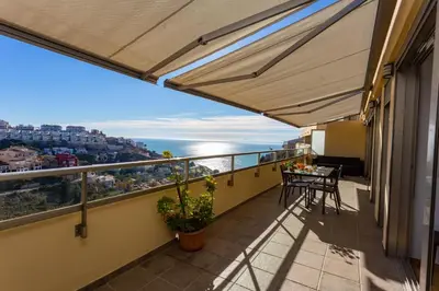 a balcony with a table and a view of the ocean at Cap Blanc Penthouse in Cullera