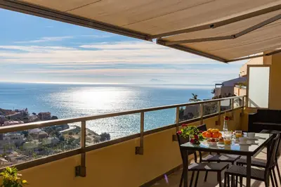 a balcony with a table with a view of the ocean at Cap Blanc Penthouse in Cullera