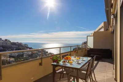 a table on a balcony with a view of the ocean at Cap Blanc Penthouse in Cullera