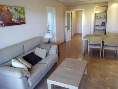 a living room with a couch and a table at Apartmento playa Almarda. Piscina&Parking in Almarda