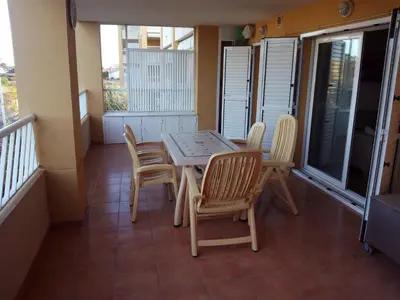 a small balcony with a table and chairs on it at Apartmento playa Almarda. Piscina&Parking in Almarda