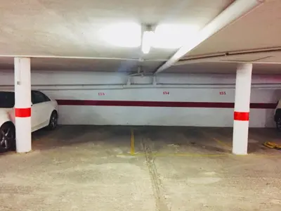 a parking garage with a white car parked in it at Apartamento en la playa Arensol Cullera in Cullera