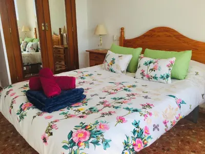 a bedroom with a large bed with flowers on it at Apartamento en la playa Arensol Cullera in Cullera