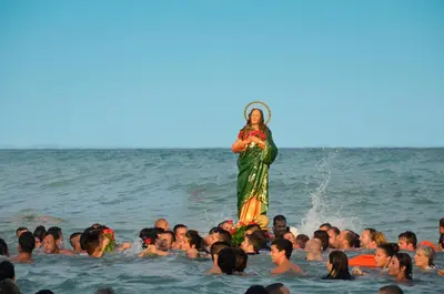 a woman standing in the water with a group of people in the water at Camping y Bungalows Monmar in Moncófar