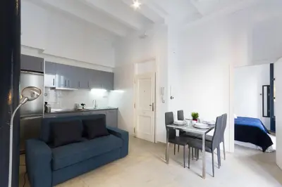 a living room with a blue couch and a table at Valentia Apartments - Mercado Central in Valencia