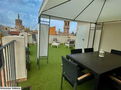 a patio with a table and chairs on a roof at Valentia Apartments - Mercado Central in Valencia
