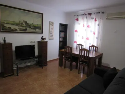 a living room with a table and chairs and a television at Apartamento Playa Malvarrosa, Valencia in Valencia