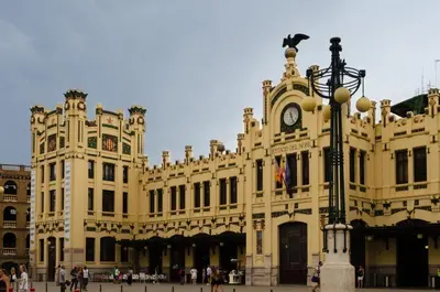 a large yellow building with a clock on it at ApartUP L' Almoina in Valencia