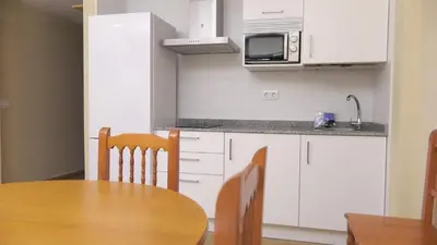 a kitchen with a wooden table and a microwave at Apartamentos Satse Moncofa in Moncófar