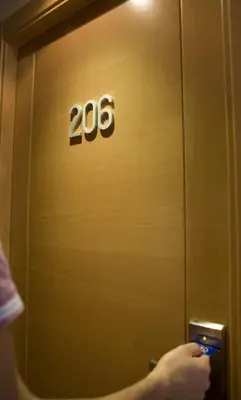 a person holding a cell phone in front of a door at Hostal Casa Paco in Chilches
