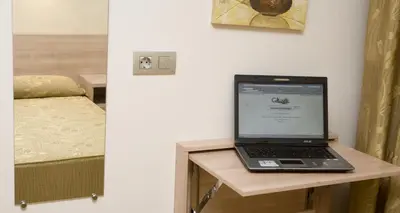 a laptop computer sitting on a table next to a bed at Hostal Casa Paco in Chilches