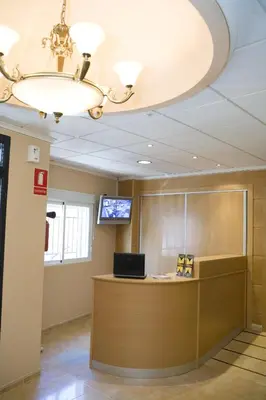 an office with a reception desk and a chandelier at Hostal Casa Paco in Chilches