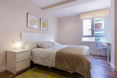 a bedroom with a bed and a desk and a window at Cedro flat in Valencia