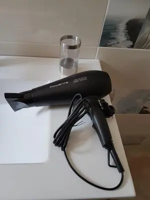 a black hair dryer on a table with a glass at Bianca in Valencia