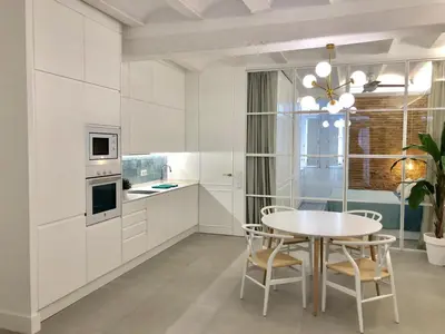 a white kitchen with a table and chairs at Apartamento Frederick “Centrico y con Clase” in Valencia