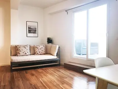 a living room with a couch and a large window at Goya atico in Valencia