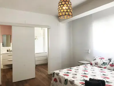 a bedroom with a bed and a room with a window at Goya atico in Valencia
