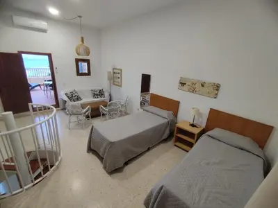 a bedroom with two beds and a living room at ValenciaBeachHome in Port Saplaya