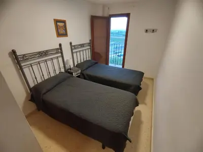 two beds in a small room with a window at ValenciaBeachHome in Port Saplaya