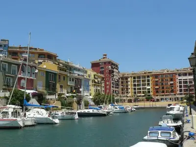 a group of boats docked in a harbor with buildings at ValenciaBeachHome in Port Saplaya